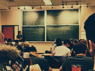 学生坐在椅子上在黑板的前面
